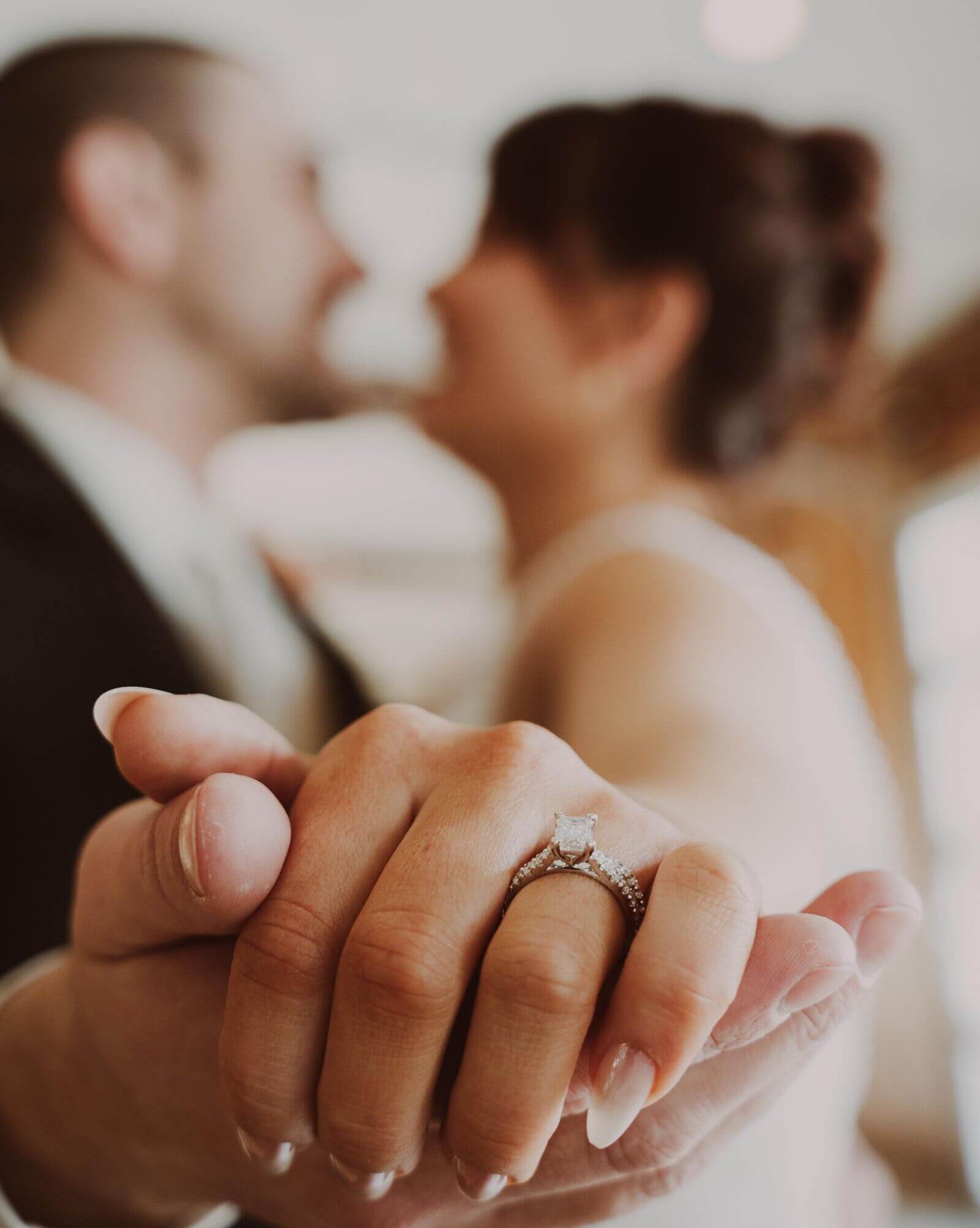 Bride & Groom holding hands with wedding ring on bride's finger.
